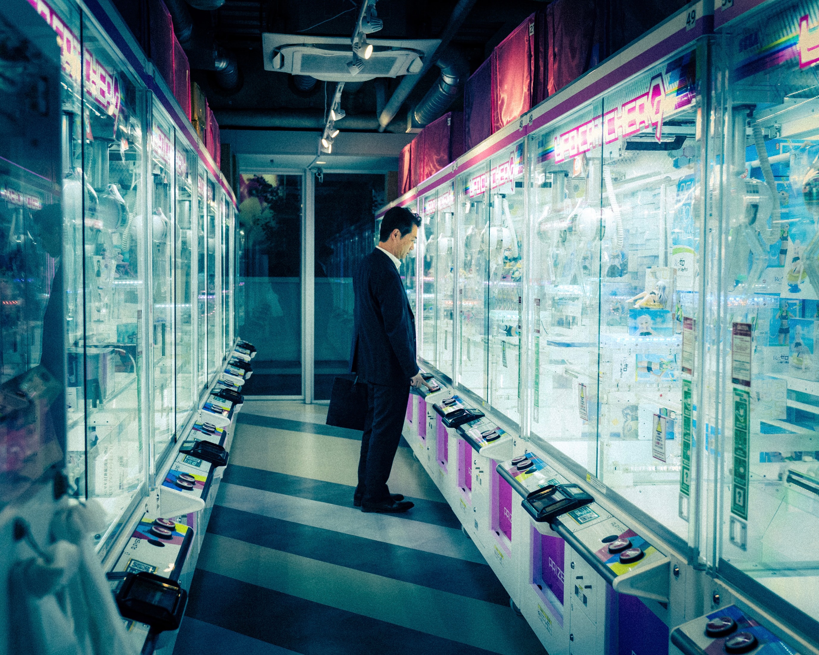 A suit stops at the claw machines on the way home.