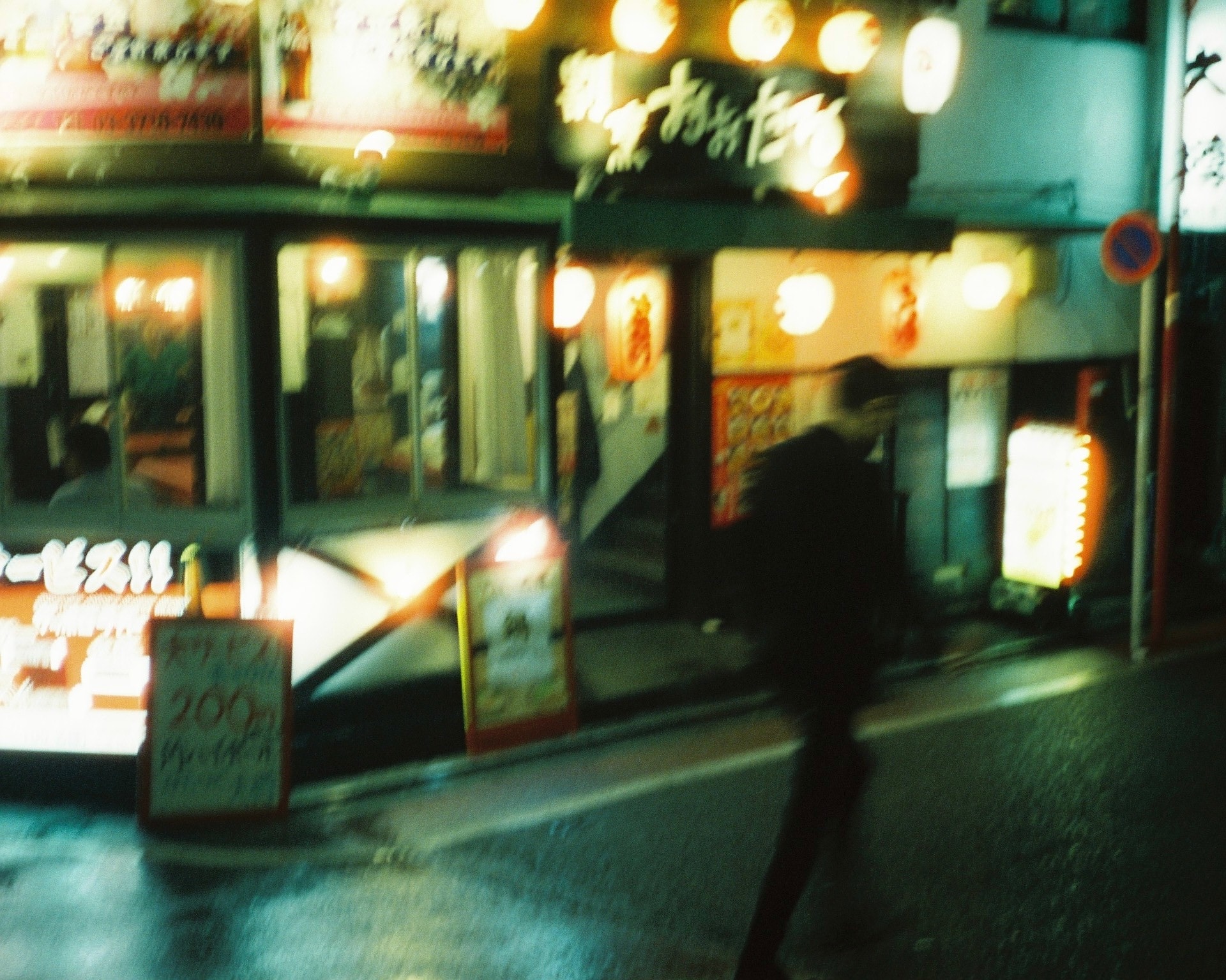 Motion blur past a lantern-lit doorway.