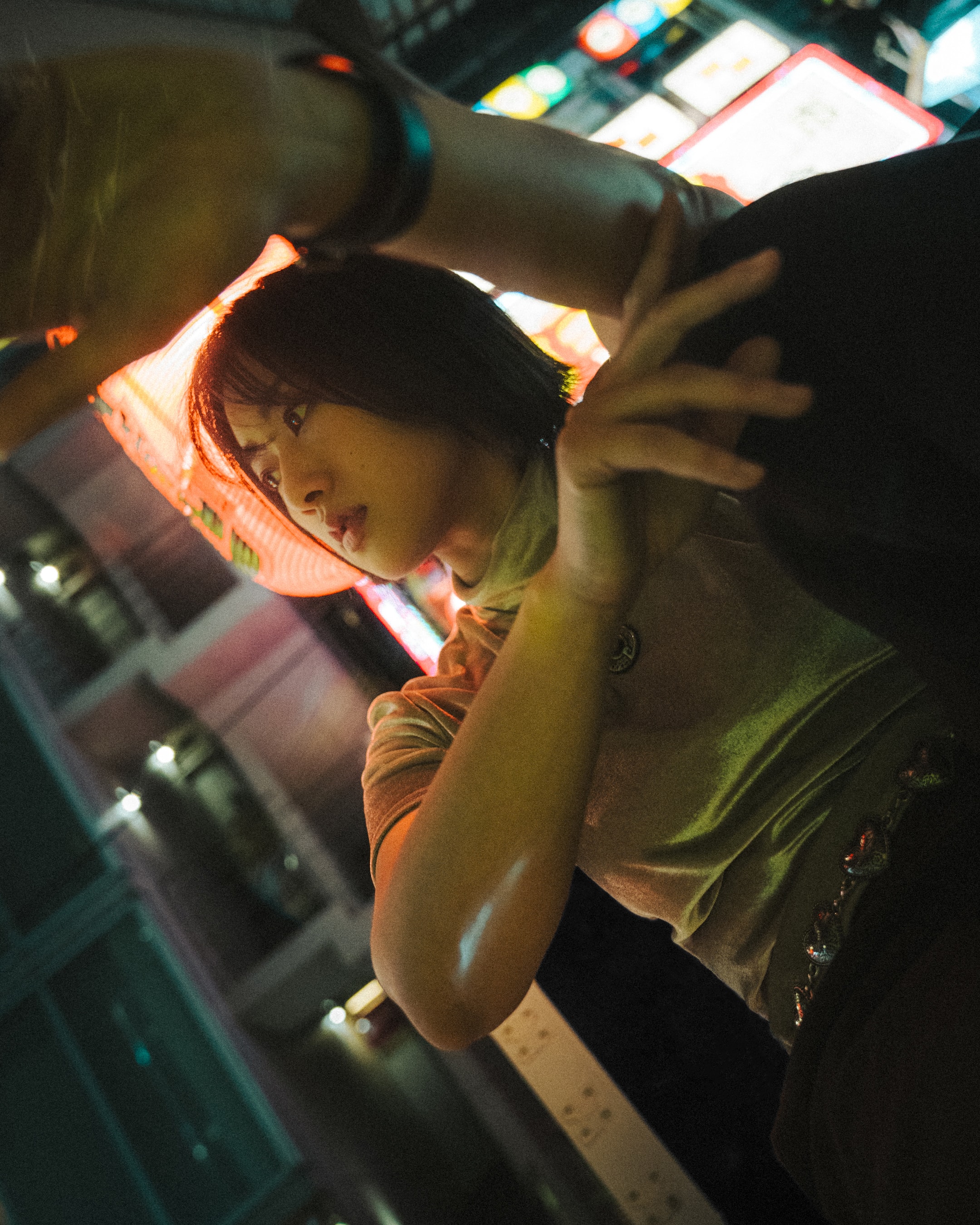A hand raised toward the neon, catching the light.
